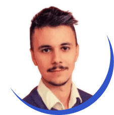 Professional headshot of a young man with a mustache, wearing a suit and a light blue shirt, against a plain background.